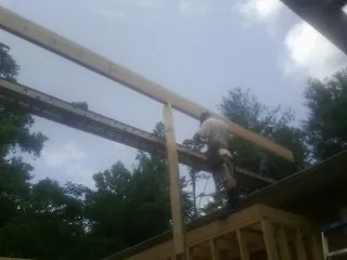 Carpenter setting a ridge beam over a new addition frame — Ice Dam Removal by Roofing Brothers in Rosebud